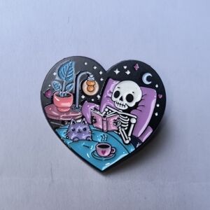 Heart Enamel Pin — Skeleton Reading in Bed (Black, Purple, Blue)